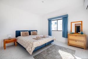 a bedroom with a bed and a dresser and a window at Cozy Apartment with indoor pool in Albufeira +13 photos