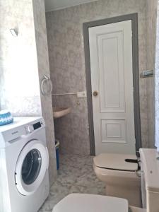 a bathroom with a washing machine and a toilet at Casa rias baixas in Poio