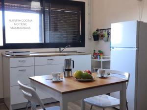a kitchen with a table with a bowl of fruit on it at Casa La Cabezada in San Sebastián de la Gomera +30 photos