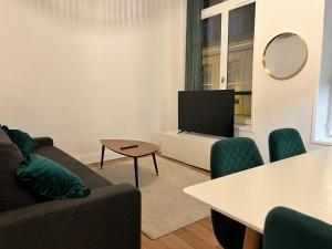 Una sala de estar con un sofá y un televisor. en Vert Gallant - Ultra Central - Parking public - Lumineux, en Arras 3 fotos más