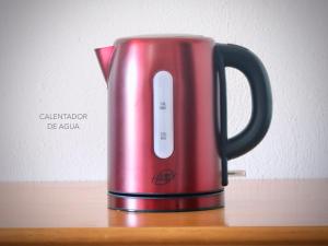 a red kettle is sitting on a wooden table at Casa La Cabezada in San Sebastián de la Gomera