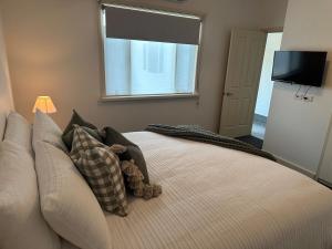 une chambre avec un lit avec un ours en peluche dessus dans l'établissement Cottage on High, à Wedderburn 3 autres photos