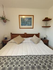 a bedroom with a large white bed with two pillows at CasaValparaluz in Valparaíso