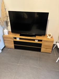 a flat screen tv sitting on top of a wooden entertainment center at Appart cosy in La Seyne-sur-Mer
