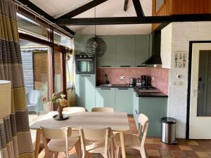 a kitchen and dining room with a table and chairs at Boerenslag 15 in Sint Maartensvlotbrug