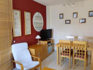 a dining room with a table and a television at Apartamento Vera-playa in Los Amarguillos