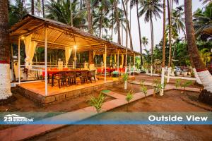 a pavilion with tables and chairs and palm trees at Sea breeze Private Pool Villa - alibaug by 29 Bungalow in Nagaon