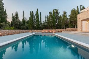 a swimming pool with blue water and a brick wall at Villa Molaris ZadarVillas in Donje Selo +28 photos