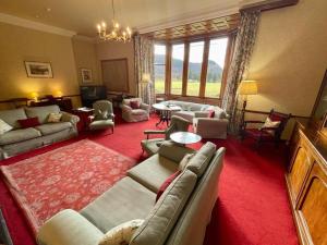 a living room with couches and a red carpet at Sherramore Lodge in Laggan