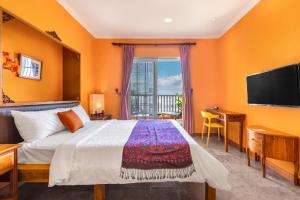 una camera da letto con un letto e una TV a schermo piatto di Golden Ocean Azure Hotel a Kenting