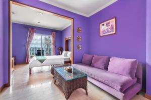 un soggiorno viola con divano e letto di Golden Ocean Azure Hotel a Kenting