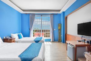 Camera blu con 2 letti e una TV di Golden Ocean Azure Hotel a Kenting