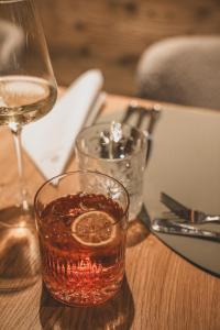 szklankę alkoholu siedzącą na stole z kieliszkiem wina w obiekcie Ferienwelt Kesselgrub Hotel in Altenmarkt-Zauchensee w mieście Altenmarkt im Pongau