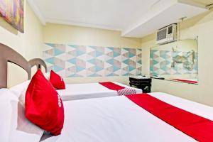 a bedroom with two beds with red pillows at OYO 894 Cosmo Hotel P Campa Manila in Manila
