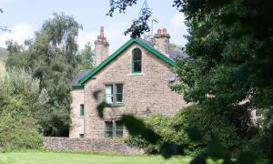 a brick house with two chimneys on top of it at Edale - Loft with a view in Edale