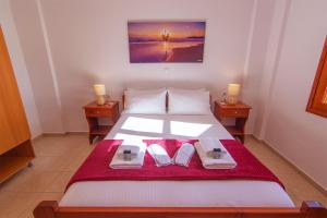 a bedroom with a bed with two napkins and two candles at Liviko Beach Apartments - only adults in Frangokastello