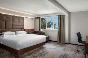 a bedroom with a bed and a desk and a window at Delta Hotels by Marriott Colchester in Colchester