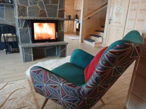 a living room with a chair and a television at Tatra West Farm in Dzianisz