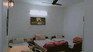 Una habitación con dos camas y un ventilador de techo. en SOLAN HOSTELz, en Solan