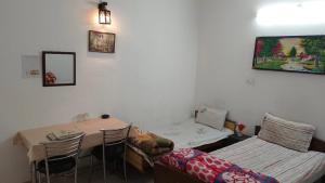 Habitación con mesa, cama, mesa y sillas. en SOLAN HOSTELz, en Solan