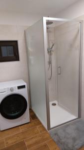 una lavatrice e una doccia in bagno di The House Next to the Forest - LAKMAT a Nové Hamry Altre 32 foto