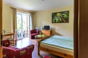 a bedroom with a bed and a table and a chair at Hotel-Pension Lindenhof in Boltenhagen