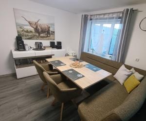 a dining room with a table with chairs and a cow on the wall at Ferienwohnung Rotheneder- Rupp in Niederndorf