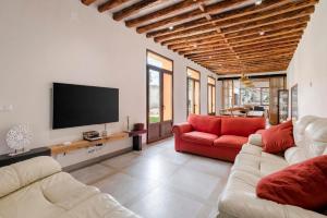 a living room with two couches and a flat screen tv at Casa Rural de Ancos, Guadamur, Toledo in Guadamur