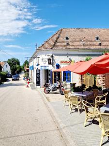 a cafe with tables and chairs on a street at Káli Cool in Káptalantóti
