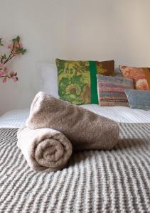 a towel on top of a bed with pillows at Beachhouse Wijk aan Zee! in Wijk aan Zee