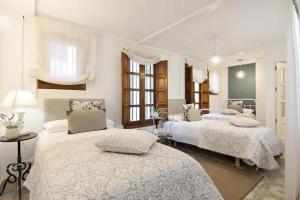 Postel nebo postele na pokoji v ubytování Apartamentos LA TONÁ Puerta Elvira centro ciudad + 21 fotografií