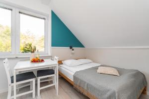 a room with two beds and a table and a window at CZTERY KĄTY - Przyjazne zwierzętom, Bezpłatne rowery, Kąty Rybackie in Kąty Rybackie
