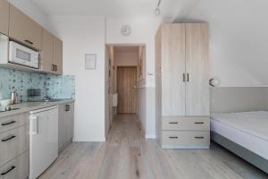 a kitchen with white cabinets and a bed in it at CZTERY KĄTY - Przyjazne zwierzętom, Bezpłatne rowery, Kąty Rybackie, Bezpłatny Meleks in Kąty Rybackie