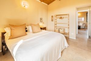 a bedroom with a large white bed and a mirror at Retrocantina Antonelli in Montefalco