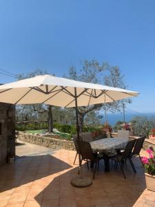 un tavolo e delle sedie sotto un ombrellone in un patio di A Sorrento B&B,relaxing location with Seaview a Sorrento