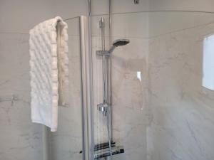 a bathroom with a shower with a towel hanging on a shower at Halmstad Golfarena stugor in Halmstad +50 photos