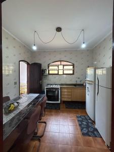 eine Küche mit Tisch und Kühlschrank in der Unterkunft Casa Praia Grande pé na areia in Praia Grande