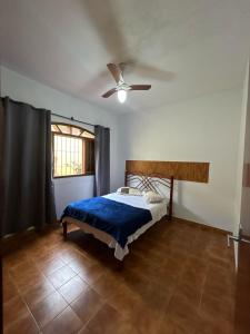 ein Schlafzimmer mit einem Bett und einem Deckenventilator in der Unterkunft Casa Praia Grande pé na areia in Praia Grande + 31 Fotos