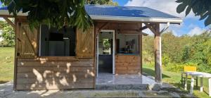 a small wooden cabin with a blue roof at Bungalow bon vivre in Saint-François
