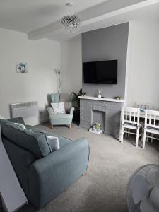 a living room with a blue couch and a fireplace at Jasmyne Cottage in Wainfleet All Saints