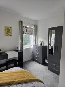 a bedroom with a bed and a desk and a window at Jasmyne Cottage in Wainfleet All Saints