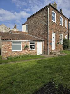 a brick house with a lawn in front of it at Jasmyne Cottage in Wainfleet All Saints