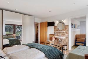 a bedroom with a large bed and a sink at Haus Janßen-Wehrle in Titisee-Neustadt