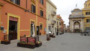 una calle en una ciudad con edificios y una torre del reloj en Antica Locanda Cavallino Bianco, en Cerveteri