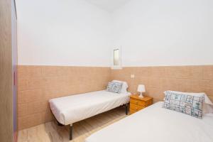a bedroom with two beds and a night stand at Casa Playa Melenara in Melenara