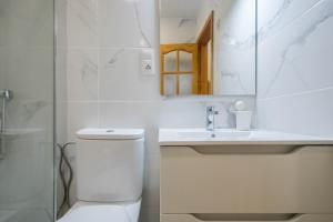a bathroom with a toilet and a sink and a mirror at Casa Playa Melenara in Melenara +34 photos
