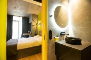 a bathroom with a sink and a bed and a mirror at Hotel CH51 in Batumi