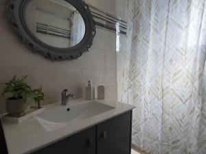 a bathroom with a sink and a mirror and a shower curtain at Aeon Blue in Sikinos
