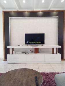 a large white entertainment center with a flat screen tv at Cosy 2 bedroom apartment in Arusha