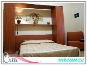 a bedroom with a bed and a mirror and a chair at Bitti vacanze in Castelvetrano Selinunte